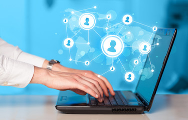Close up of hand with laptop and social media icons