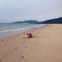 ballet dancer doing the split on the beach