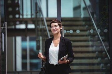 Smiling businesswoman holding digital tablet