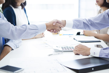 Business people with a handshake at the real estate agency