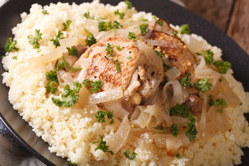 Traditional African food: poulet Yassa with onion and couscous macro. horizontal