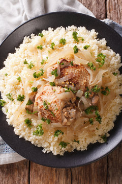 Senegalese cuisine: chicken Yassa with couscous and onions close-up. Vertical top view
