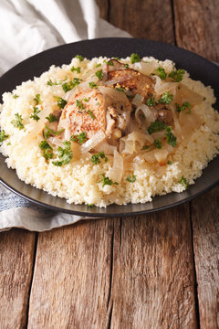 Poulet Yassa stewed with onions and garnished with couscous close up. vertical
