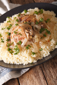 Senegalese cuisine: chicken Yassa with couscous and onions close-up. vertical

