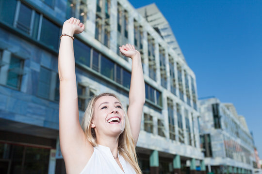 cheering business woman with copy space in blue sky