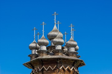 Fototapeta na wymiar Domes of Church of the Intercession against deep blue sky, Kizhi Island, Russia. Ancient wooden architecture. UNESCO heritage landmark