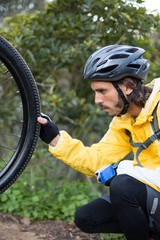 Naklejka premium Male biker repairing mountain bike