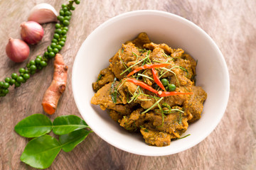 Hot and spicy pork curry traditional local Thai food with herbs, pepper, turmeric, chili, onion and kaffir lime leaves. Delicious and famous Thailand food.