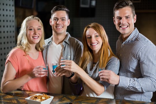 Group of friends standing at bar counter