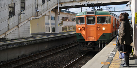 Fototapeta na wymiar Orange vintage lowspeed local train approaching the platform