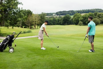 Fototapeta na wymiar Male instructor assisting woman in learning golf