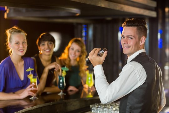 Portrait of waiter and beautiful woman standing at bar counter