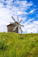 Rural landscape. Traditional wooden windmill on green hill. Kizhi Island. Karelia, Russia. UNESCO heritage landmark