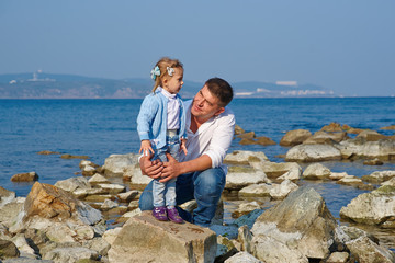 Happy father and his little daughter at beach