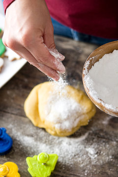 Woman pouring flour in the christmas cookies sourdough
