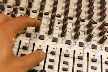 Professional audio mixing console with faders and adjusting knobs