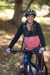 Naklejka premium Female biker with mountain bike in countryside