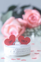 Marriage proposal ring with roses in background