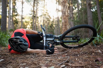 Male mountain biker fallen from his bicycle in the forest 