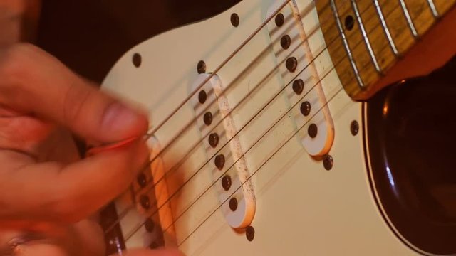 Guitarist Touches Electric Guitar Neck Strings in Night Bar