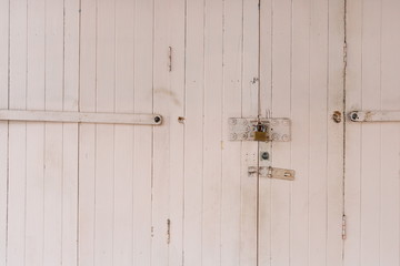 Old wooden door locked with golden padlock - Old town in Thailand