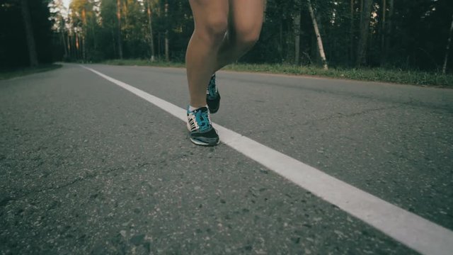 Woman running on asphalt road, super slow motion. HD.