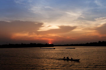 Silhouette of long tail boat on Tapee river Suratthani Thailand in evening time