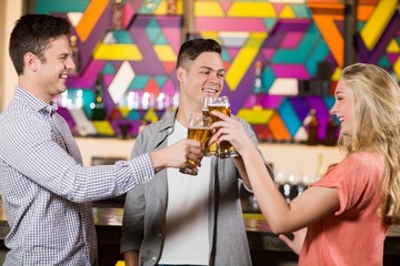 Three friends toasting glasses of beer
