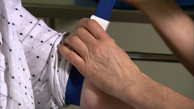 Nurse putting tourniquet on patients arm
