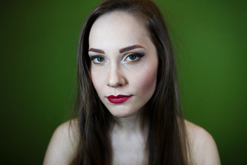 Fototapeta premium Portrait of a beautiful young girl on a dark green background