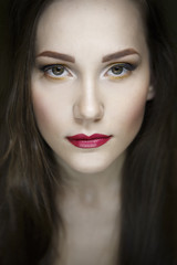 Fototapeta premium Portret pięknej młodej dziewczyny na ciemnozielonym tle
