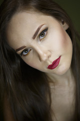 Obraz premium Portrait of a beautiful young girl on a dark green background