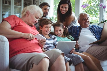 Happy family using laptop, mobile phone and dig