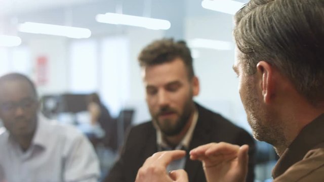 Two workers listening to their boss during conference.