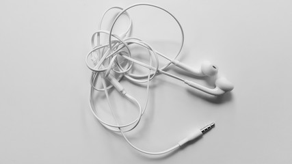 Tangled headphone cable on white background isolated.