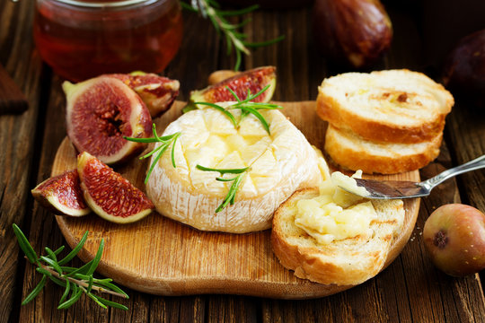 Brie cheese on a wooden board with fresh figs and honey.selective focus.