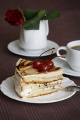 Portrait of a slice of cake with tea and a rose on a table
