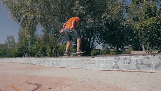 Young man jumping high on a skateboard in skate park. Slow motion, 100 fps. HD.