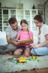 Parents and daughter reading a book 