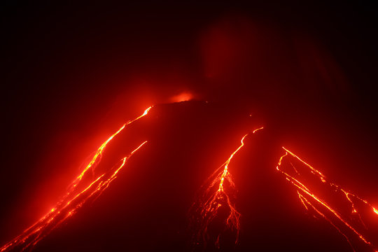 Volcanic landscape of Kamchatka: night view of eruption Klyuchevskaya Sopka, current lava flows on the slope of the volcano. Russian Far East, Kamchatka Region, Klyuchevskaya Group of Volcanoes.