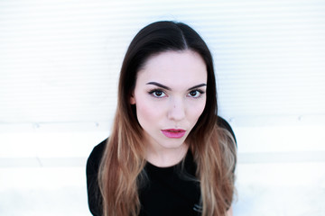 Fototapeta premium Portrait of beautiful girl in black dress on light background
