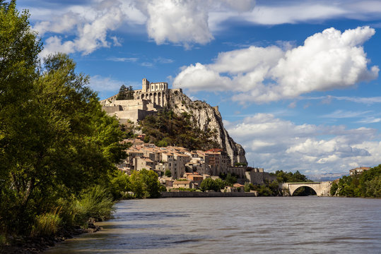 Citadel of Sisteron and Durance River on summer with clouds in afternoon light. Sisteron and its fortifications is located in the Southern Alps (Alpes de Haute Provence). France