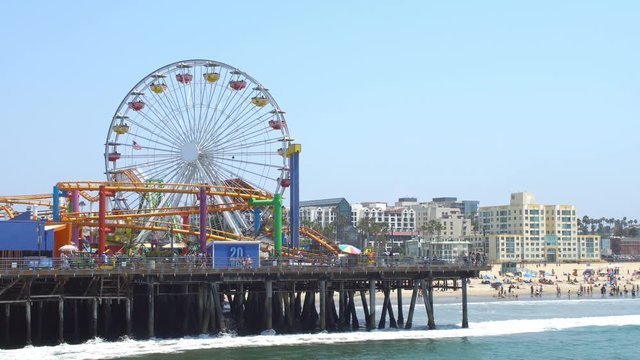 Santa Monica, California, 29th July 2016: Tourists on the Santa Monica Pier, riding the roller coaster and the Ferris wheel