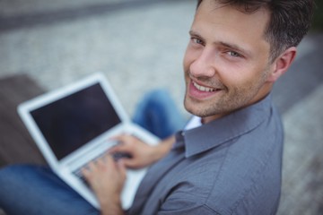 Portrait of handsome business executive using laptop