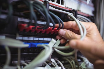 Technician plugging patch cable in a rack mounted server