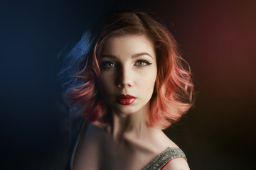 Portrait of a beautiful girl in a black suit on a black background