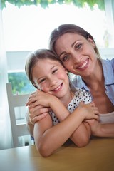 Fototapeta premium Happy mother and daughter embracing at home
