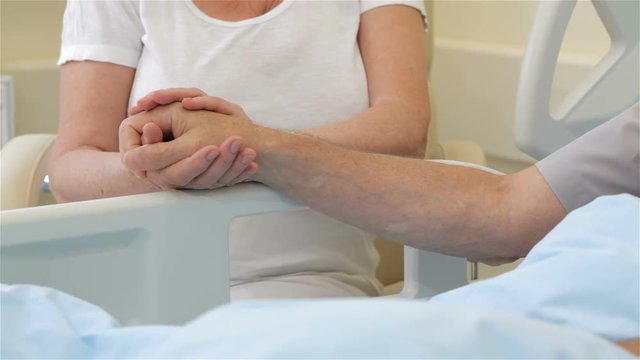 Senior ill man put his hand on his wife's palm
