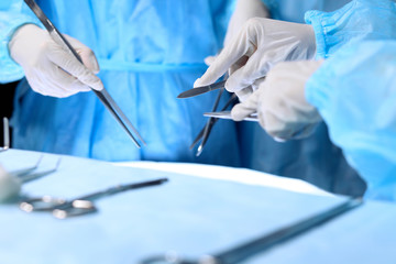 Medical team performing operation. Group of surgeon is working in operating theatre toned in blue