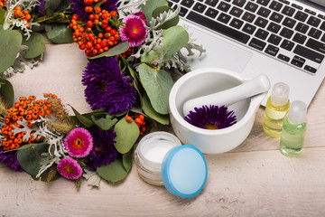 Seasonal skincare products with flowers on a wooden background